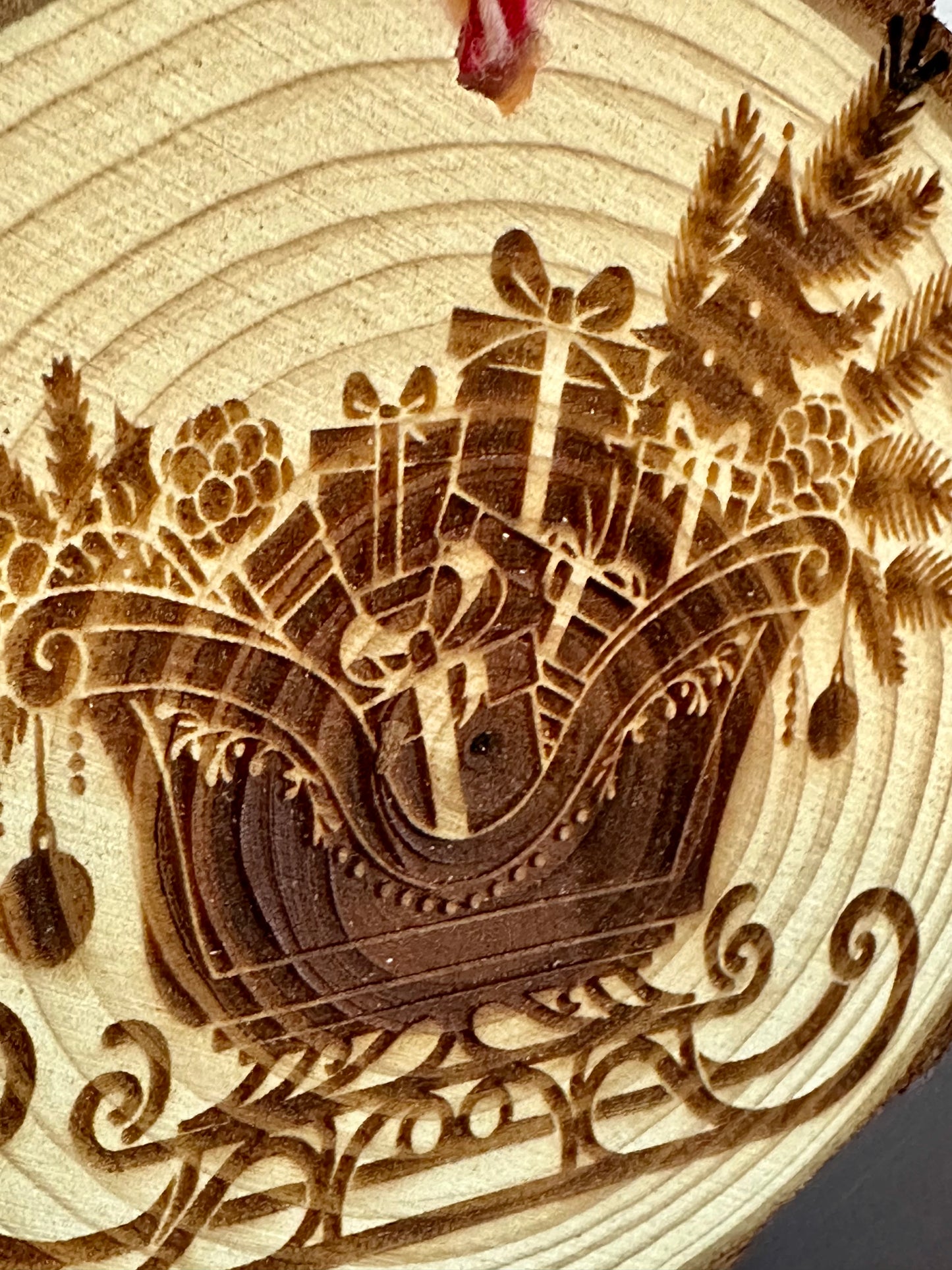 Engraved Live Edge Wooden Round Ornament - Presents and Pine in Sleigh